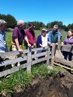 Personen stehen hinter Zaun